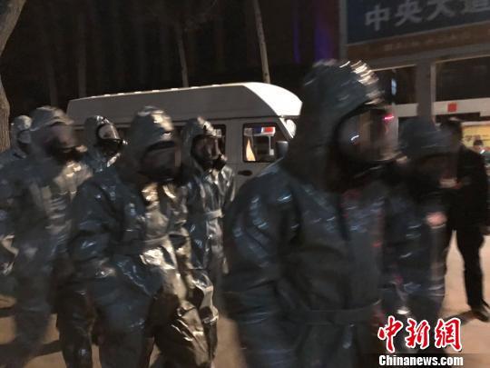 十几名身着防护服的人员头戴面具进入事发地。　胡健 摄